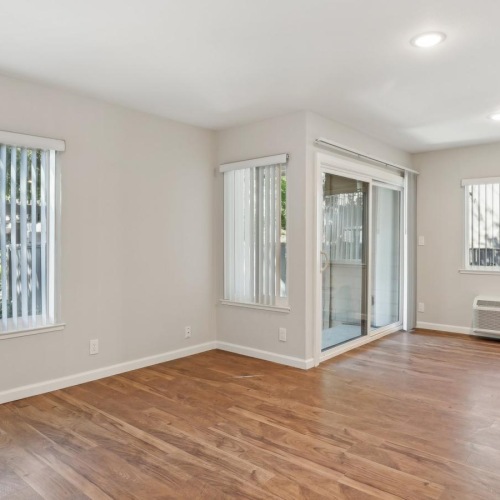 a room with a wood floor and windows