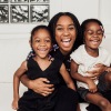 a mom and two young girls sitting on a couch and laughing