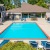 pool area with reclining seats and landscaping