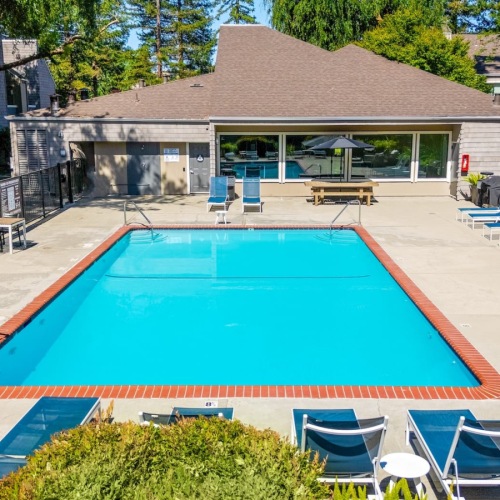 pool area with reclining seats and landscaping